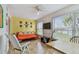 Bright Florida Room with futon, guitar, dining table, ceiling fan, and lots of light at 2280 World Parkway Blvd # 34, Clearwater, FL 33763