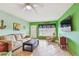 Bright living room featuring tile flooring, a cream sofa, and green accent walls at 2280 World Parkway Blvd # 34, Clearwater, FL 33763