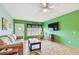 Open living room with tile flooring, a neutral sofa, and vibrant green accent wall at 2280 World Parkway Blvd # 34, Clearwater, FL 33763
