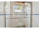 Walk-in shower featuring a tile surround, glass door, and mounted shower head at 2280 World Parkway Blvd # 34, Clearwater, FL 33763