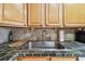 Close-up of kitchen sink with tiled countertops, wooden cabinets, and backsplash at 2280 World Parkway Blvd # 34, Clearwater, FL 33763