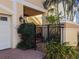 Charming front entrance with brick walkway, iron gate, and lush landscaping at 249 Iron Age St., Safety Harbor, FL 34695