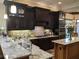Kitchen featuring granite countertops, tile backsplash, stainless steel appliances, and dark wood cabinets at 249 Iron Age St., Safety Harbor, FL 34695