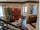 Living room with chandelier, dark wood floors, and white rugs viewed from staircase, adding a cozy ambiance at 249 Iron Age St., Safety Harbor, FL 34695