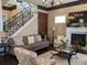 Living room features a fireplace, decorative stone accent wall, staircase with wrought iron and hardwood floors at 249 Iron Age St., Safety Harbor, FL 34695