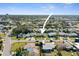 Wide aerial shot of a residential area with a mix of houses and green spaces, surrounded by open fields at 2491 Coronado Way, Dunedin, FL 34698