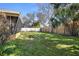 Lush backyard with a mix of grass and landscaping, enclosed by a fence at 2491 Coronado Way, Dunedin, FL 34698