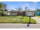 Charming single-story home with a well-maintained lawn, complemented by a driveway and an attached garage at 2491 Coronado Way, Dunedin, FL 34698