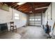 Spacious unfinished garage featuring exposed ceiling beams and a roll-up door, providing ample storage and utility space at 2491 Coronado Way, Dunedin, FL 34698