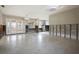 Expansive living area ready for renovation, featuring terrazzo floors and ample natural light through French doors and windows at 2491 Coronado Way, Dunedin, FL 34698