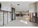 Open concept space with a kitchen featuring white cabinets and a large living area with a light-colored tile floor at 2491 Coronado Way, Dunedin, FL 34698