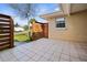 An outdoor patio with a wood-slatted fence, a view of the neighborhood, and a tiled floor at 2491 Coronado Way, Dunedin, FL 34698
