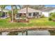 Charming backyard patio with a screened-in porch, overlooking a serene pond with lush landscaping at 29523 Waggle Dr, San Antonio, FL 33576