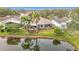 Aerial view of a well-maintained home featuring a screened-in porch and a scenic pond in the backyard at 29523 Waggle Dr, San Antonio, FL 33576