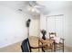 This is a bedroom with a ceiling fan and natural lighting, neutral colored tile, and a rocking chair at 29523 Waggle Dr, San Antonio, FL 33576