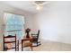 Cozy bedroom featuring neutral tile floors, a ceiling fan, and a large window with natural lighting at 29523 Waggle Dr, San Antonio, FL 33576