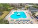 Beautiful community pool area with a unique design, featuring ample seating and a serene pond backdrop at 29523 Waggle Dr, San Antonio, FL 33576