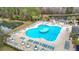 Aerial view of a large community pool surrounded by lounge chairs and tables, perfect for relaxation at 29523 Waggle Dr, San Antonio, FL 33576