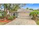 Charming single-story home features a paver driveway, tropical landscaping, and a neutral color scheme at 29523 Waggle Dr, San Antonio, FL 33576