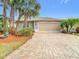 Charming single-story home features a paver driveway, tropical landscaping, and a neutral color scheme at 29523 Waggle Dr, San Antonio, FL 33576