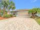 Charming single-story home features a paver driveway, tropical landscaping, and a neutral color scheme at 29523 Waggle Dr, San Antonio, FL 33576