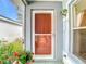 Cozy front porch with a charming screen door and colorful hanging flowers at 29523 Waggle Dr, San Antonio, FL 33576