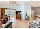 Inviting living room with tile flooring, ceiling fan, and sliding glass doors to the lanai at 29523 Waggle Dr, San Antonio, FL 33576