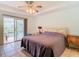 Cozy main bedroom featuring a ceiling fan, a private access to the screened lanai, and tile flooring at 29523 Waggle Dr, San Antonio, FL 33576