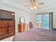 Comfortable main bedroom with a ceiling fan, access to the screened lanai, and decorative furniture at 29523 Waggle Dr, San Antonio, FL 33576