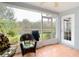 Relaxing screened-in patio featuring comfortable seating and tranquil views of the lush backyard and pond at 29523 Waggle Dr, San Antonio, FL 33576
