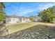 Wide shot of the backyard with a large lawn and access to the home at 3624 Wiltshire Dr, Holiday, FL 34691
