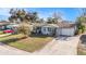 Charming single-story home featuring a well-manicured lawn and a long driveway, perfect for parking at 3624 Wiltshire Dr, Holiday, FL 34691
