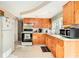 Functional kitchen featuring wood cabinets, modern appliances, and ample counter space at 3624 Wiltshire Dr, Holiday, FL 34691