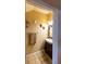 Well-lit powder room with tiled floor and a classic vanity sink at 3673 Kings Rd # 102, Palm Harbor, FL 34685