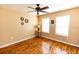 A well-lit bedroom featuring wood floors, a ceiling fan, and two large windows at 3673 Kings Rd # 102, Palm Harbor, FL 34685