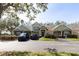 Townhome complex with mature trees and a tidy parking area and landscaping on sunny day at 3673 Kings Rd # 102, Palm Harbor, FL 34685