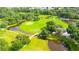 Lush aerial view of a golf course with winding fairways, ponds, wooden bridge and mature trees at 37150 Sandra Ave, Zephyrhills, FL 33542