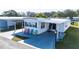Aerial view of a mobile home with driveway and several colorful chairs at 37150 Sandra Ave, Zephyrhills, FL 33542
