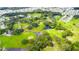 Aerial view of lush golf course community with winding waterways, mature trees, and manicured greens at 37150 Sandra Ave, Zephyrhills, FL 33542