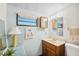 Well-lit bathroom with a wooden vanity, light blue walls, and decorative accents at 37150 Sandra Ave, Zephyrhills, FL 33542