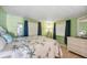 Comfortable bedroom with green walls, bamboo-themed bedding, and wicker furniture at 37150 Sandra Ave, Zephyrhills, FL 33542