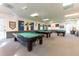 A billiards room with multiple tables, soft lighting, and a welcoming atmosphere for recreational enjoyment at 37150 Sandra Ave, Zephyrhills, FL 33542