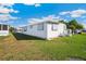 Exterior view of a white mobile home with lawn and partially clouded blue sky at 37150 Sandra Ave, Zephyrhills, FL 33542