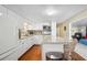 Modern kitchen with white cabinetry, a sleek island with barstools, and hardwood flooring at 37150 Sandra Ave, Zephyrhills, FL 33542