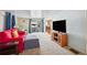 Bright living room with plush carpeting, a red sofa, and a sliding glass door at 37150 Sandra Ave, Zephyrhills, FL 33542