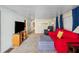 Inviting living room with a red sofa, light walls, plush carpeting, and a TV at 37150 Sandra Ave, Zephyrhills, FL 33542