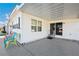 View of a covered patio with sliding glass door and several colorful chairs at 37150 Sandra Ave, Zephyrhills, FL 33542