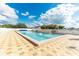 Outdoor neighborhood swimming pool with tiled area for chairs and umbrellas at 37150 Sandra Ave, Zephyrhills, FL 33542