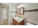The bathroom features a sink, vanity, mirror and tiled accents for an updated look at 4101 W Leila Ave, Tampa, FL 33616