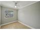 This cozy bedroom has a ceiling fan, window, tile flooring and neutral paint for easy personalization at 4101 W Leila Ave, Tampa, FL 33616
